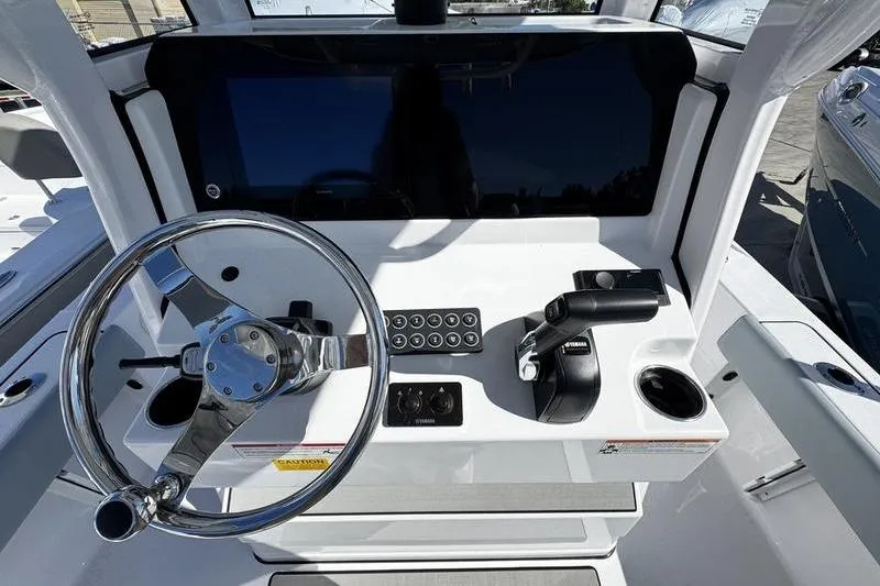 Slide: The Image of 2026 Sportsman Masters 227 Bay Boat helm with steering wheel and controls. - 13