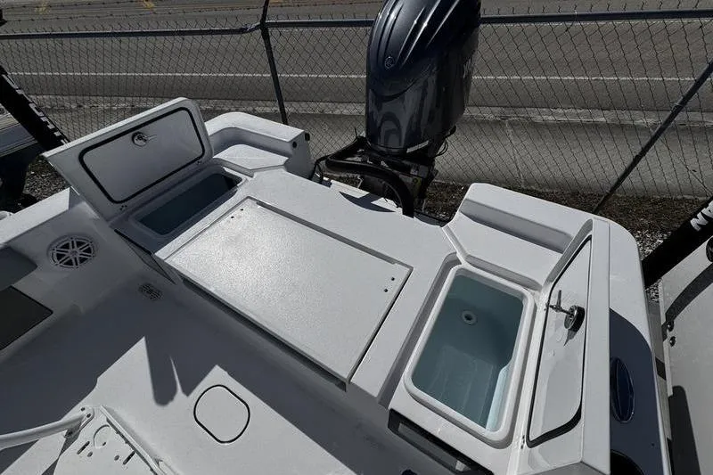 Slide: The Image of 2026 Sportsman Masters 227 Bay Boat deck with storage compartments and outboard motor. - 15