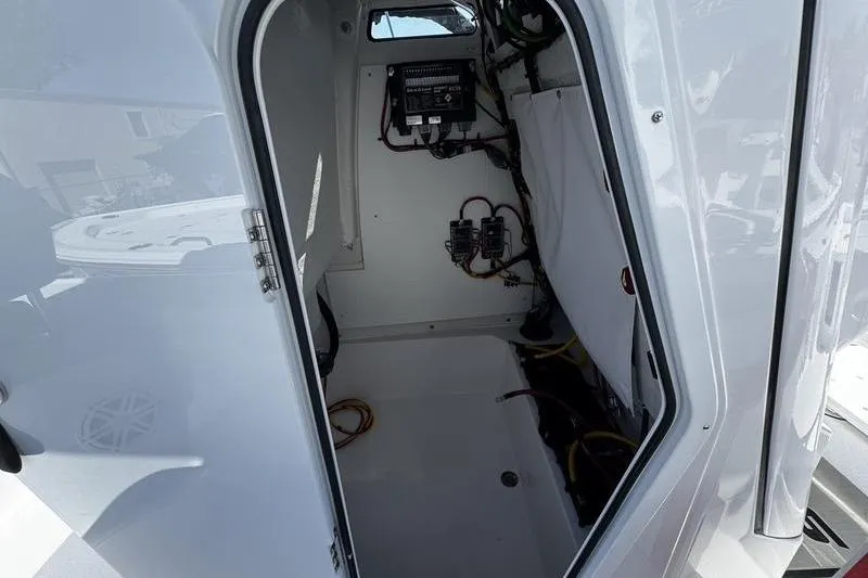 Slide: The Image of 2026 Sportsman Masters 227 Bay Boat interior wiring and storage compartment. - 19