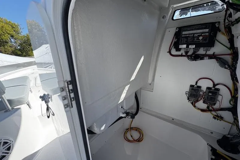 Slide: The Image of 2026 Sportsman Masters 227 Bay Boat interior wiring and storage compartment. - 21