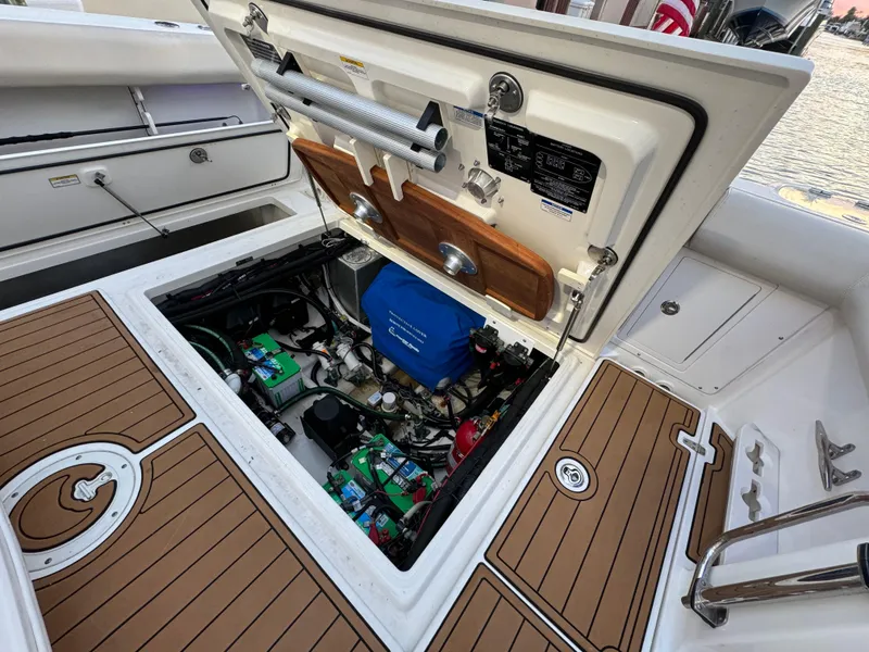 Slide: The Image of 2017 Boston Whaler 370 Outrage engine compartment with open hatch, showcasing internal components. - 11