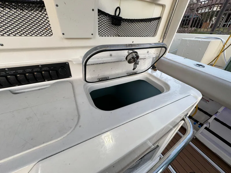 Slide: The Image of 2017 Boston Whaler 370 Outrage boat with open storage compartment and control panel. - 15