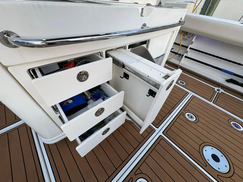 Slide: The Image of 2017 Boston Whaler 370 Outrage boat with open storage compartments on deck. - 16