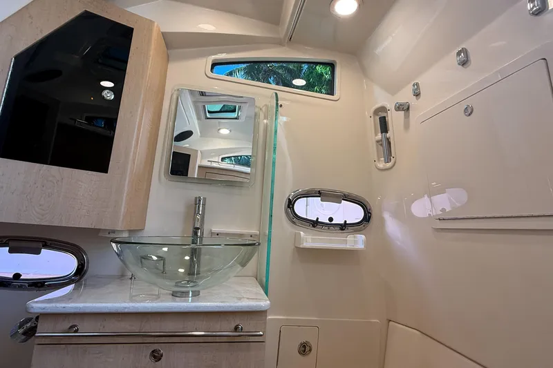 Slide: The Image of Luxurious bathroom interior of 2017 Boston Whaler 370 Outrage with modern fixtures and glass sink. - 30