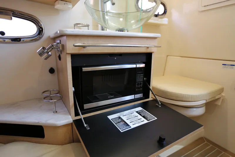 Slide: The Image of 2017 Boston Whaler 370 Outrage interior with microwave, sink, and seating area. - 34