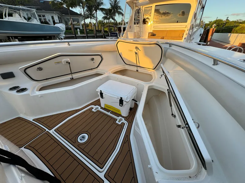 Slide: The Image of 2017 Boston Whaler 370 Outrage boat interior with open storage compartments and cooler. - 40
