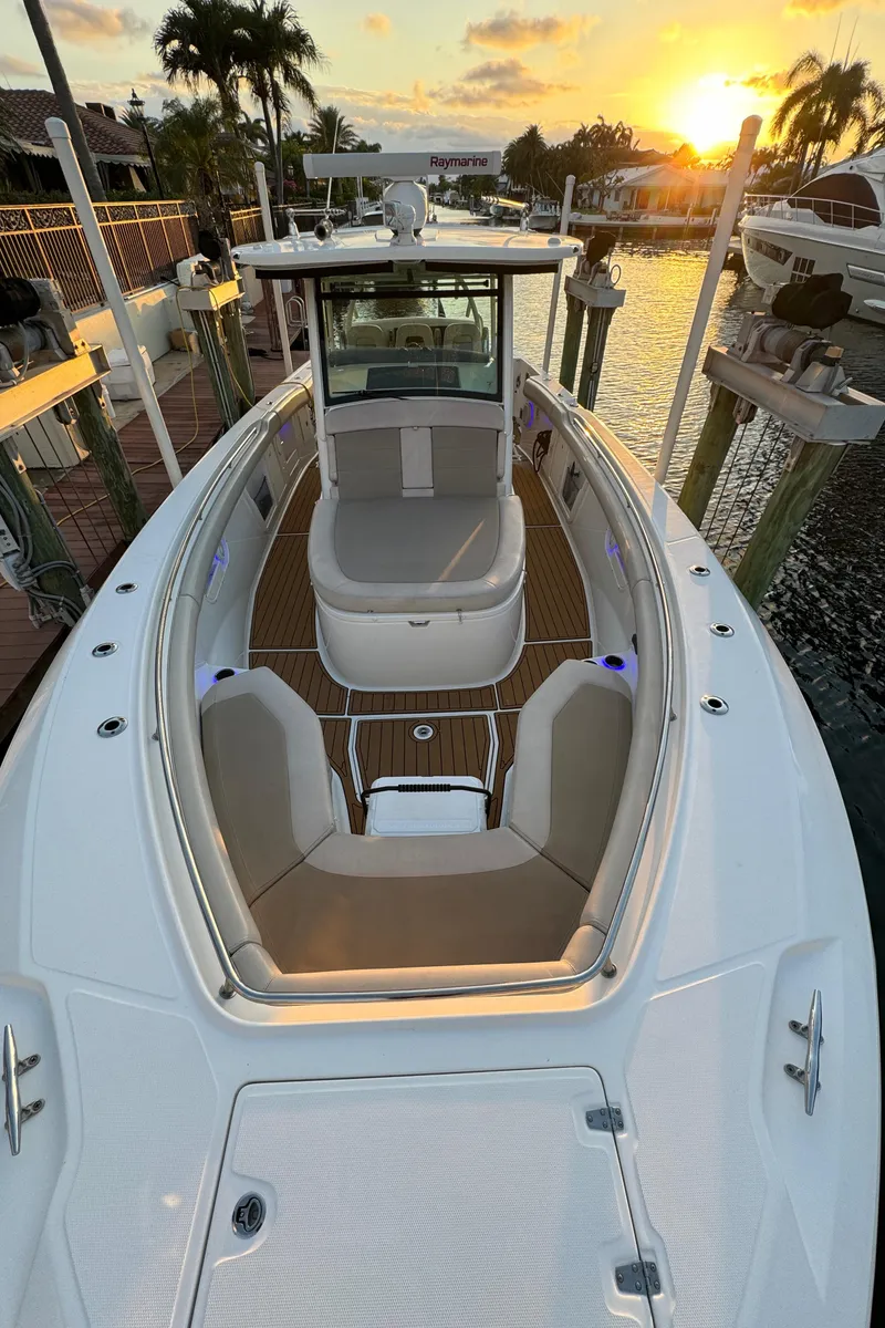 Slide: The Image of 2017 Boston Whaler 370 Outrage boat at sunset, docked by palm trees. - 47