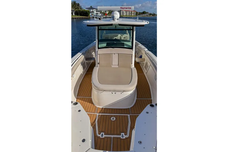 Slide: The Image of 2017 Boston Whaler 370 Outrage boat with teak deck, docked on calm water. - 48