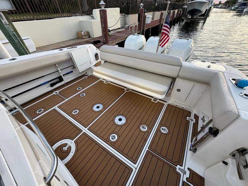 Slide: The Image of 2017 Boston Whaler 370 Outrage boat with teak deck and seating, docked by the water. - 6
