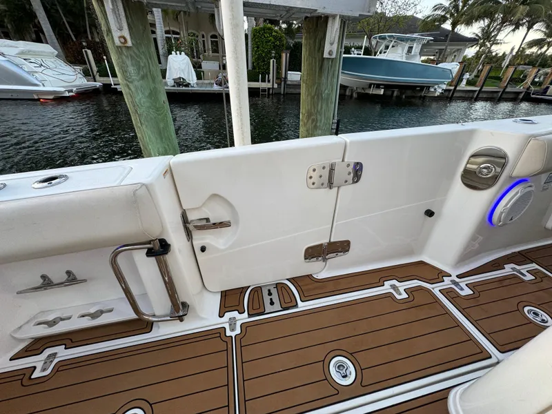 Slide: The Image of 2017 Boston Whaler 370 Outrage boat interior with teak flooring and dockside view. - 8