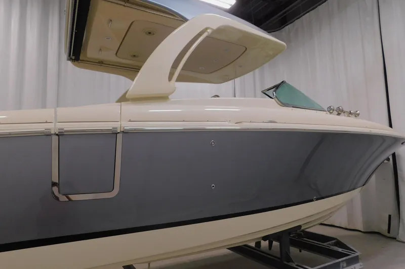 Slide: The Image of 2024 Chris-Craft Launch 31 GT boat in showroom, side view with sleek design. - 3