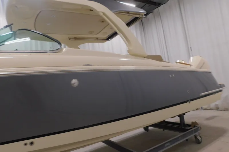 Slide: The Image of 2024 Chris-Craft Launch 31 GT boat in showroom, side view with sleek design. - 5