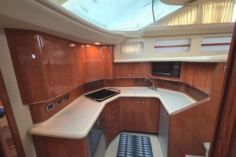 Slide: The Image of Luxurious 2000 Sea Ray 420 Aft Cabin yacht kitchen with wood cabinetry and modern appliances. - 14