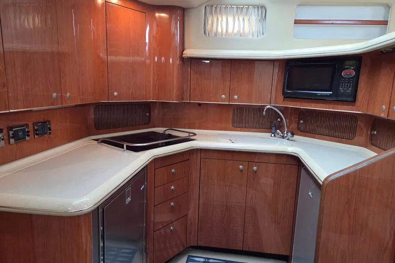 Slide: The Image of Luxurious kitchen in 2000 Sea Ray 420 Aft Cabin yacht with wood cabinetry and modern appliances. - 15