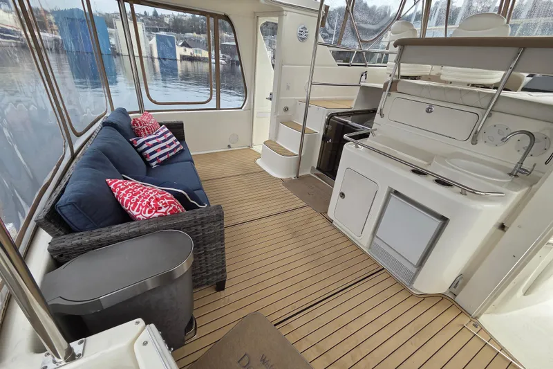 Slide: The Image of 2000 Sea Ray 420 Aft Cabin interior with seating, kitchenette, and scenic water view. - 2