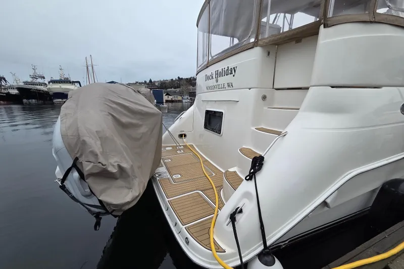 Slide: The Image of 2000 Sea Ray 420 Aft Cabin yacht docked, featuring covered outboard motor and elegant deck design. - 24
