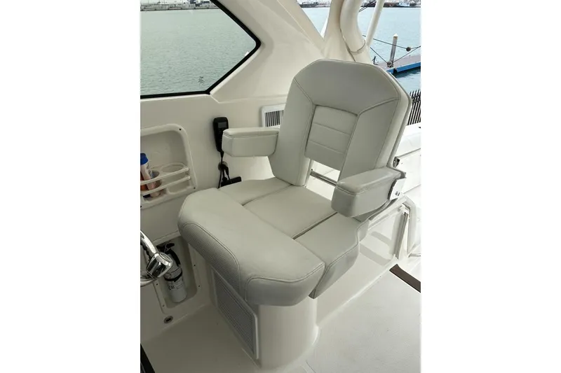 Slide: The Image of 2023 Pursuit OS 355 Offshore boat seat with armrests, overlooking water. - 17