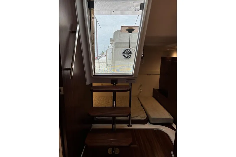 Slide: The Image of Interior view of 2023 Pursuit OS 355 Offshore boat cabin with stairs and seating area. - 25