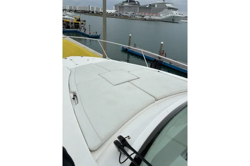 Slide: The Image of 2023 Pursuit OS 355 Offshore boat docked at marina with cruise ships in background. - 28