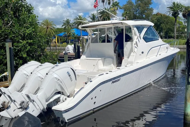 Slide: The Image of 2023 Pursuit OS 355 Offshore boat docked, featuring triple Yamaha engines, under cloudy skies. - 3
