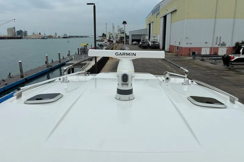 Slide: The Image of 2023 Pursuit OS 355 Offshore boat docked, featuring Garmin radar system. - 32