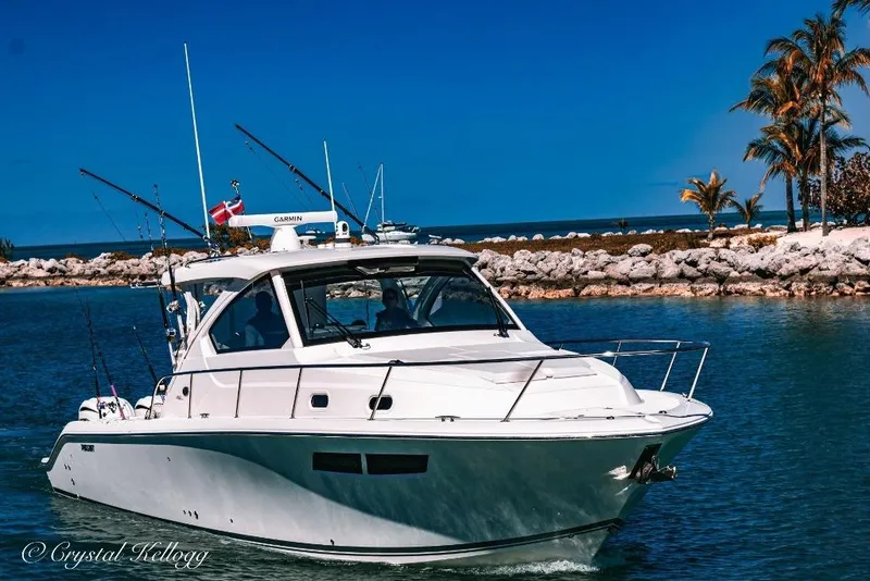 Slide: The Image of 2023 Pursuit OS 355 Offshore boat on clear water under a bright sky. - 4