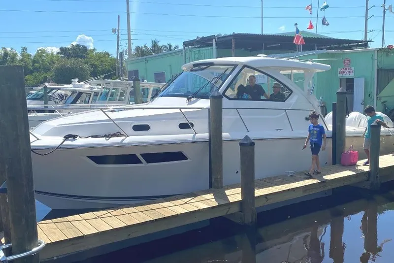 Slide: The Image of 2023 Pursuit OS 355 Offshore boat cruising in tropical waters with fishing rods. - 6