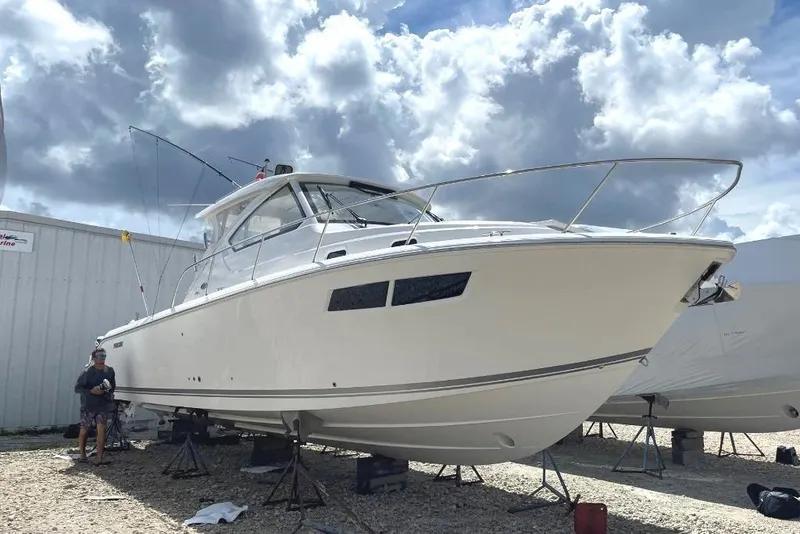 Slide: The Image of 2023 Pursuit OS 355 Offshore boat docked at marina during evening. - 7