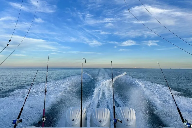 Slide: The Image of 2023 Pursuit OS 355 Offshore boat docked with people onboard and children nearby. - 8