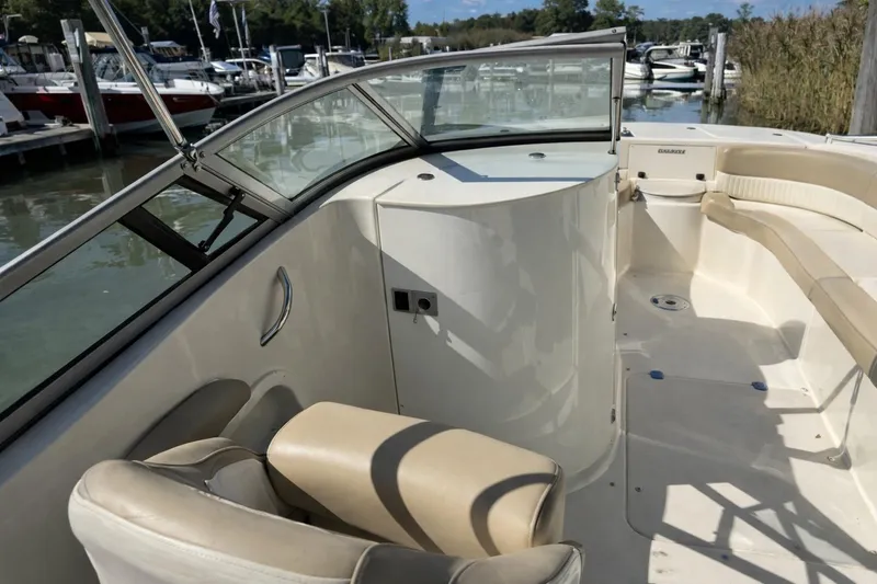 Slide: The Image of 2017 Stingray 234 LR boat interior with beige seating and sleek design at a marina. - 1
