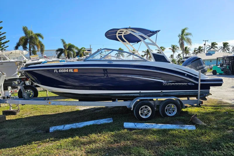 The Image of 2008 Chaparral 230 Suncoast boat on trailer, parked outdoors with palm trees in background. - 0