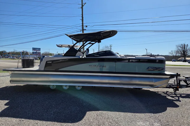 Slide: The Image of 2026 Avalon Platinum Catalina 2785 Elite Windshield pontoon boat on trailer, parked outdoors. - 3