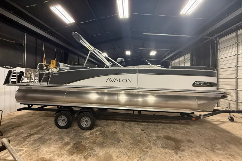 Slide: The Image of 2026 Avalon Catalina Quad Lounger Shift Windshield pontoon boat in a garage setting. - 1