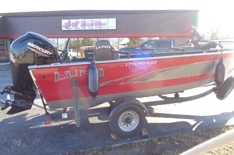 Slide: The Image of 2021 Lund 1775 Pro Guide boat with Mercury engine on trailer, parked outside dealership. - 5