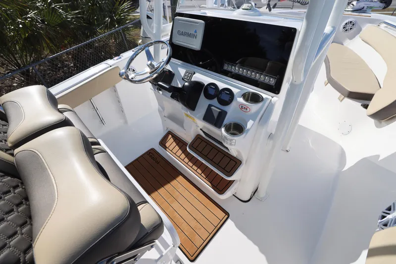 Slide: The Image of 2022 Tidewater 220 CC Adventure boat cockpit with Garmin display and cushioned seating. - 19