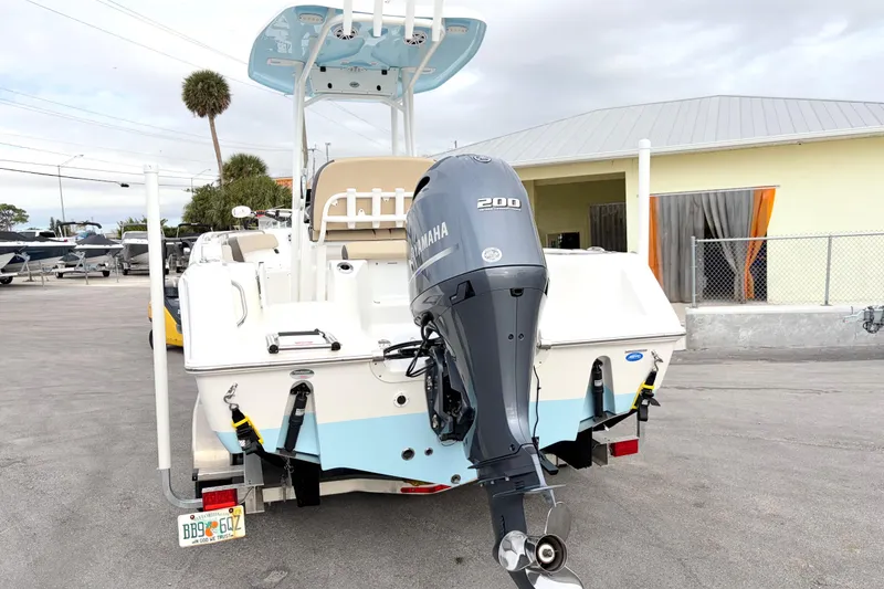 Slide: The Image of 2022 Tidewater 220 CC Adventure boat with Yamaha 200 engine, parked outdoors. - 2