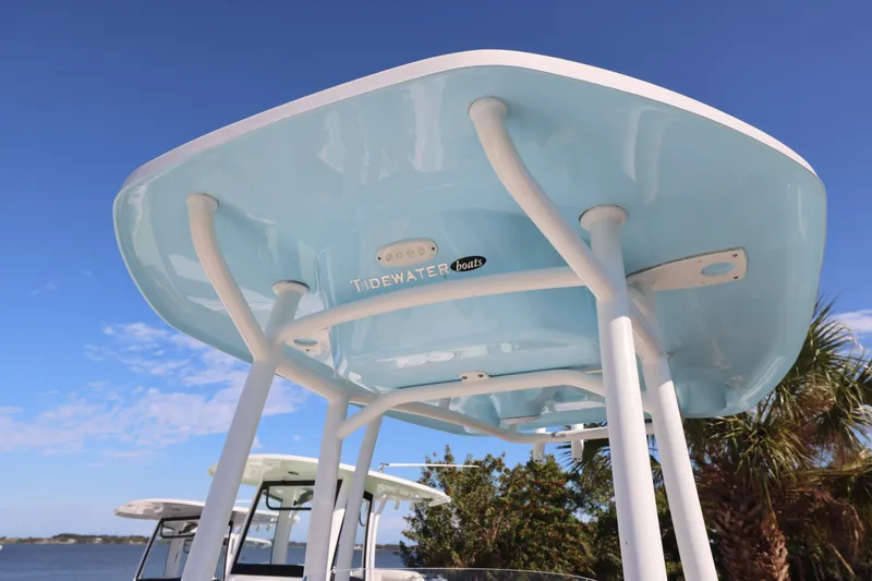Slide: The Image of 2022 Tidewater 220 CC Adventure boat with blue T-top against clear sky. - 23