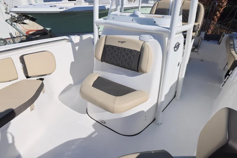 Slide: The Image of 2022 Tidewater 220 CC Adventure boat interior with beige seating and white console. - 24