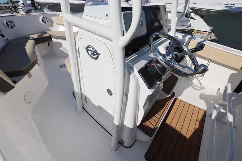 Slide: The Image of 2022 Tidewater 220 CC Adventure boat interior with steering wheel and seating area. - 9