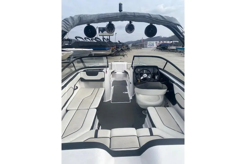 Slide: The Image of 2017 Yamaha Boats AR210 interior with seating and steering wheel, docked outdoors. - 8