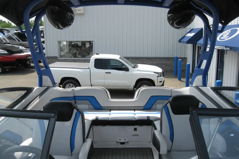 Slide: The Image of 2018 Yamaha Boats 242X E-Series interior with blue accents, parked near a white truck. - 31