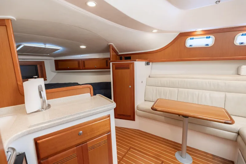 Slide: The Image of Interior of 2000 Cabo 35 Express yacht with wood accents and cozy seating area. - 10