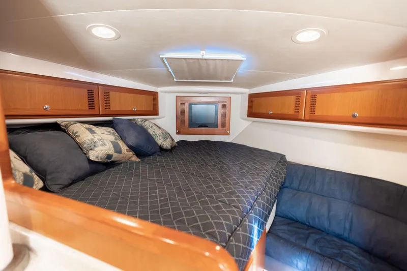 Slide: The Image of Luxurious cabin interior of 2000 Cabo 35 Express yacht with cozy bedding and wooden cabinets. - 12
