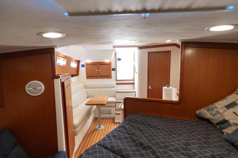 Slide: The Image of Interior of 2000 Cabo 35 Express yacht with cozy seating and wooden finishes. - 13