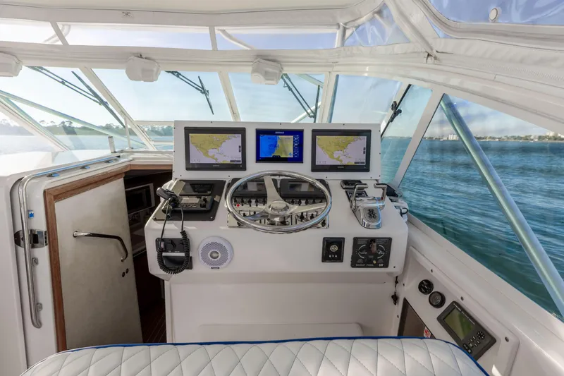 Slide: The Image of Helm of 2000 Cabo 35 Express boat with navigation screens and steering wheel. - 18