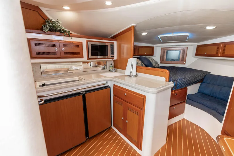 Slide: The Image of Luxurious interior of 2000 Cabo 35 Express yacht with kitchenette and cozy sleeping area. - 2