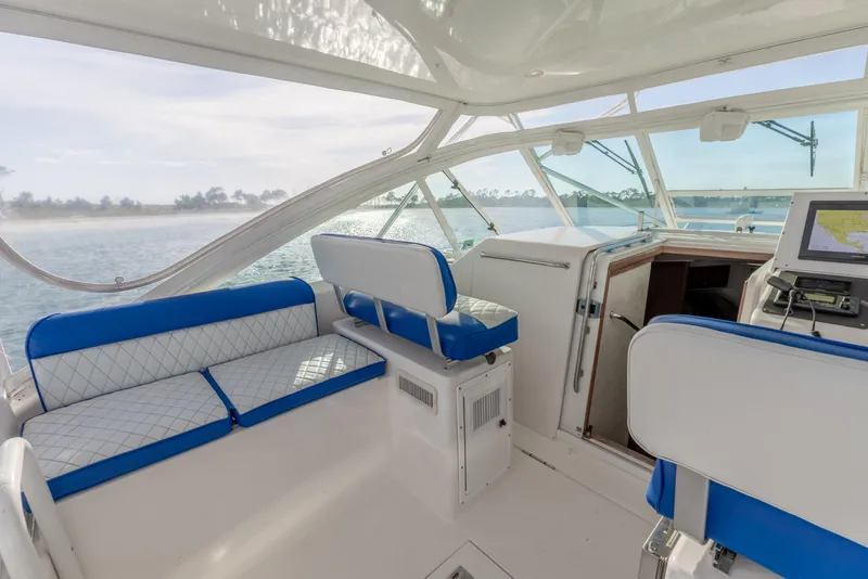 Slide: The Image of Interior of 2000 Cabo 35 Express boat with blue and white seating, overlooking water. - 22