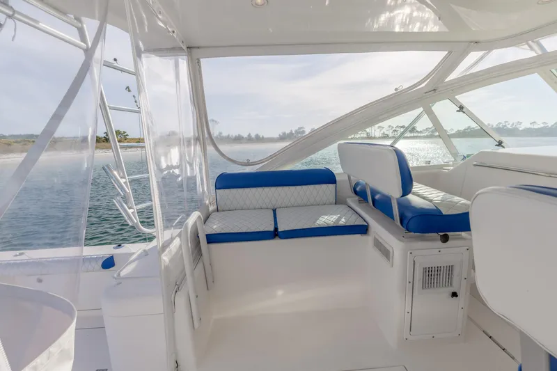 Slide: The Image of Interior of 2000 Cabo 35 Express boat with blue and white seating, overlooking water. - 23