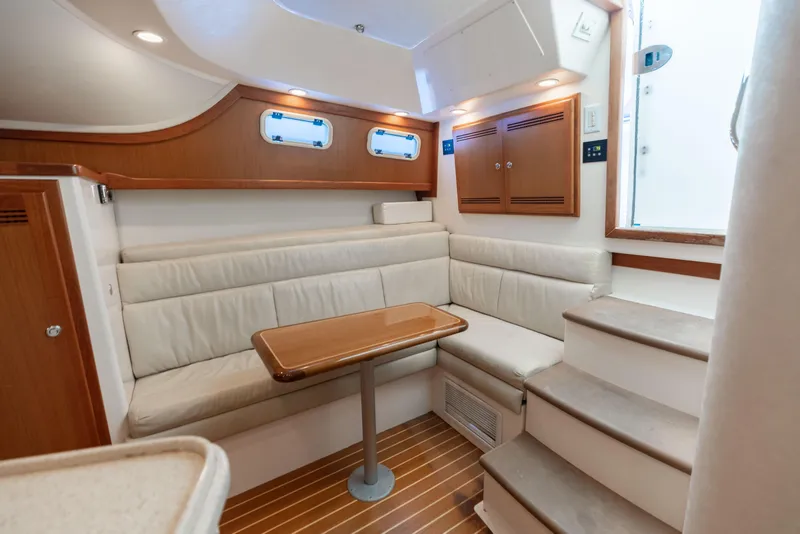 Slide: The Image of Interior of 2000 Cabo 35 Express yacht with cozy seating and wooden accents. - 8