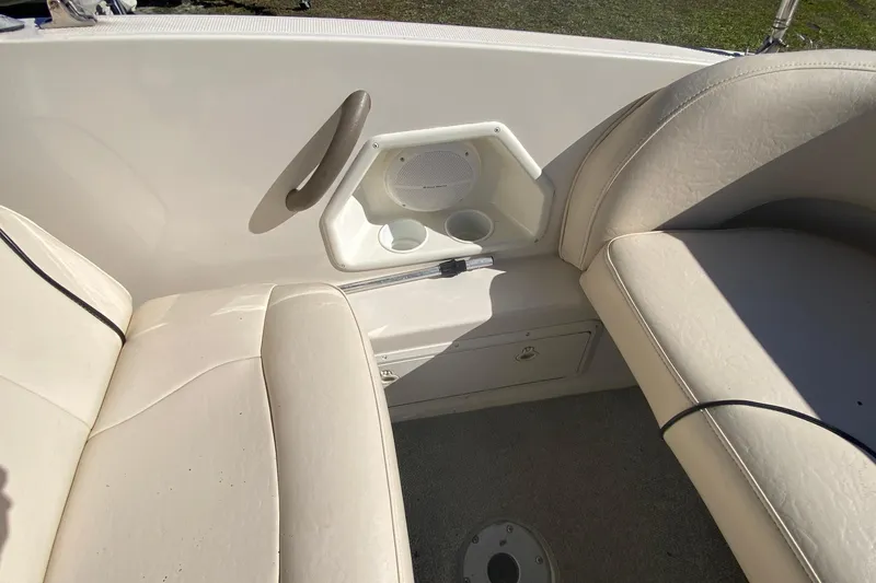 Slide: The Image of 2004 Monterey 245 Cruiser interior with beige seating, cup holders, and speaker. - 13